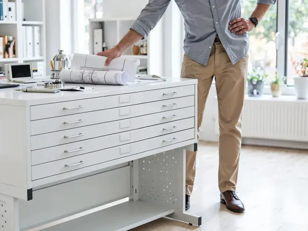 An organized flat file system with labeled drawers and separated artwork, showing an effective method for archiving art pieces